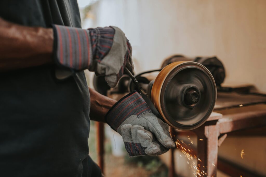 pexels-photo-1659749-1659749 A craftsman using a grinder with sparks flying indoors, showcasing skill and precision.